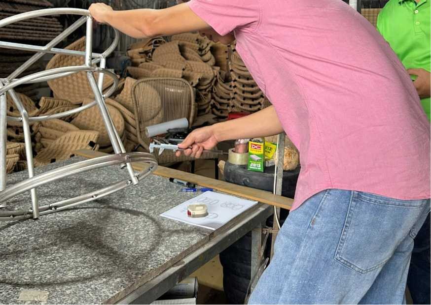Technician measuring a curved aluminum outdoor furniture frame